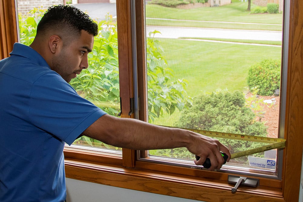 window world installer employee measuring windows